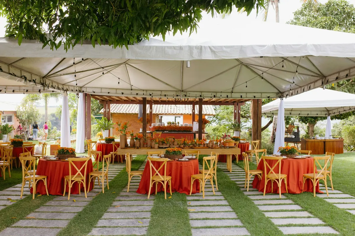 White event tents shading dining tables and a catering area at an outdoor business event
