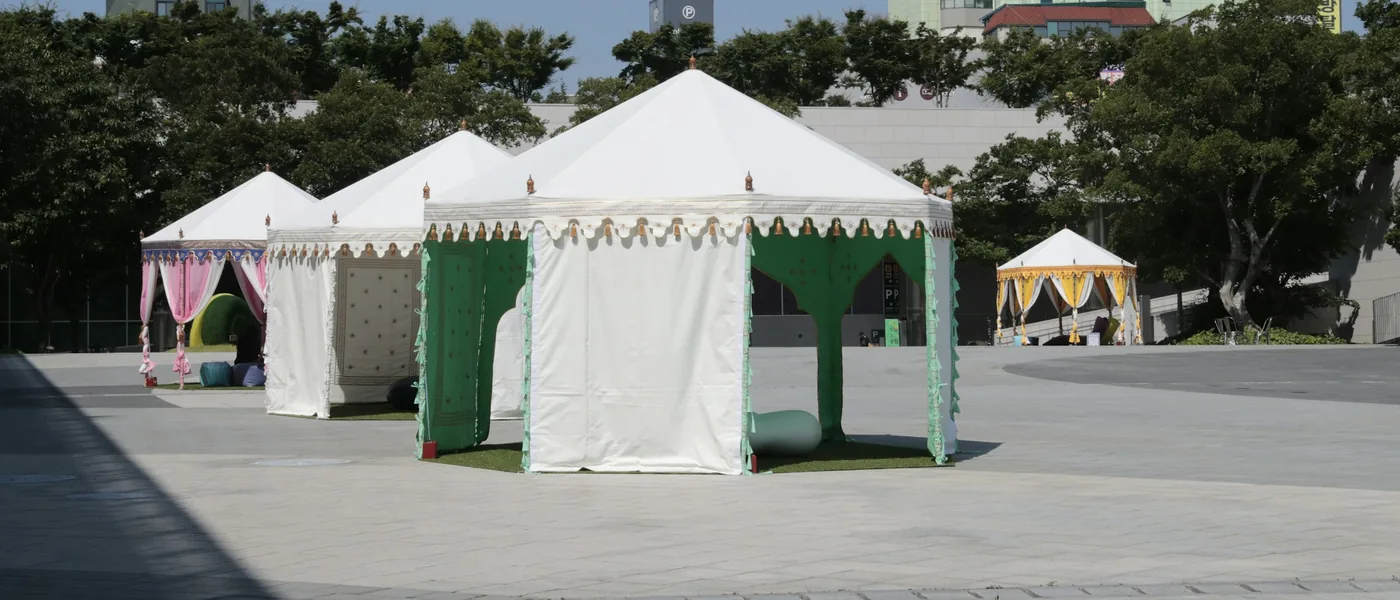 Frame tents set up on a paved concrete plaza for an outdoor exhibit